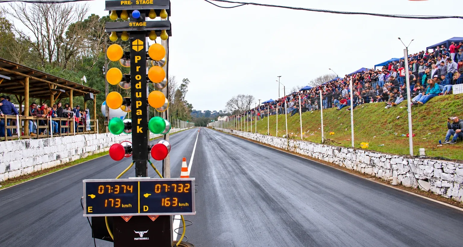 Árvore de largada e placar eletrônico marcando 173 km/h, com a arquibancada lotada ao longo da pista